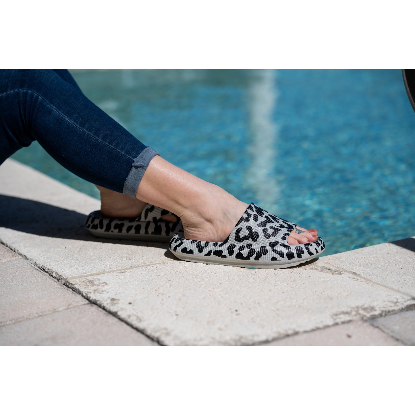 Gray leopard-print beach slides with a bold spotted pattern and easy slip-on design.